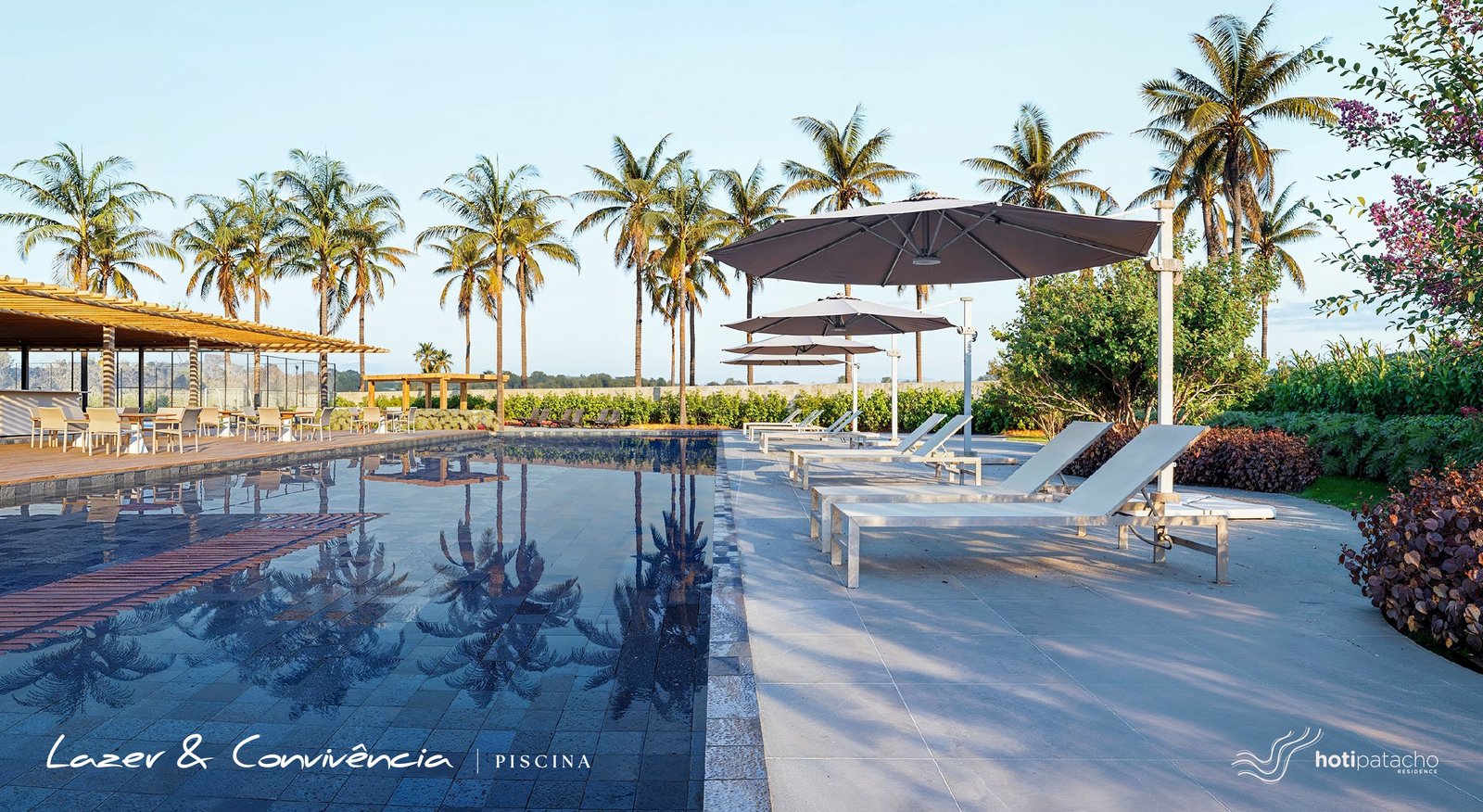 Piscina do clube do Hoti Patacho Residence com deck de madeira e coqueiros ao redor